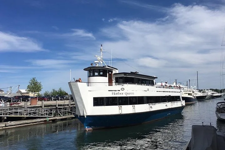 Ein großes weißes Ausflugsboot namens Harbor Queen legt im Jachthafen an