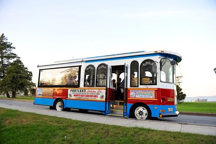 Ein blau-weiß-roter Sightseeing-Trolley-Bus, der an einer Straße parkt